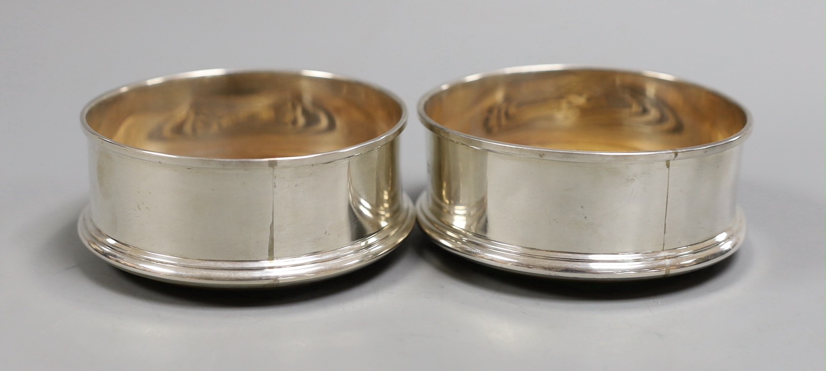 A pair of modern silver mounted wine coasters, M.C. Hersey & Son Ltd, London, 1993, diameter 9cm.
